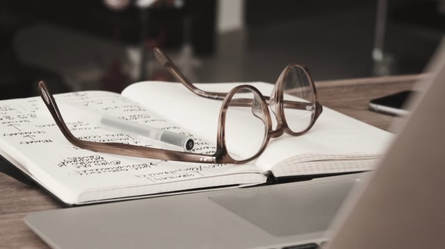 An image of a notebook and glasses used to transfer content over into a system.